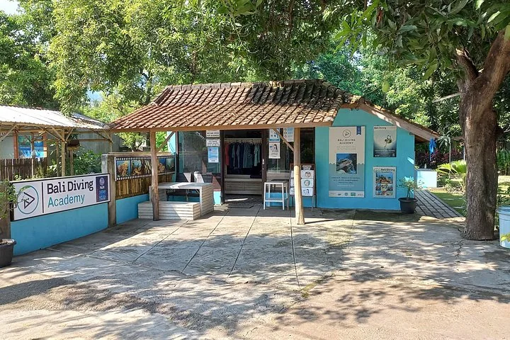 Exterior view of the Bali Diving Academy building surrounded by trees.